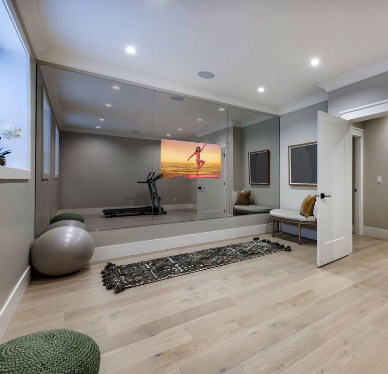 custom mirror TV installation built into home gym wall with in-ceiling audio speakers